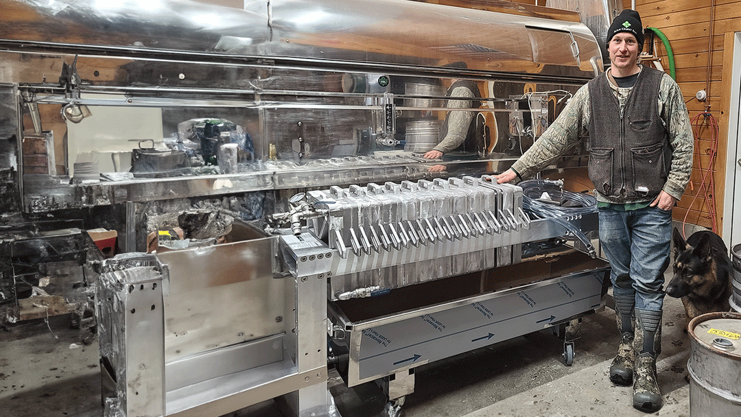 Levon standing by the new filter press used for maple syrup production.