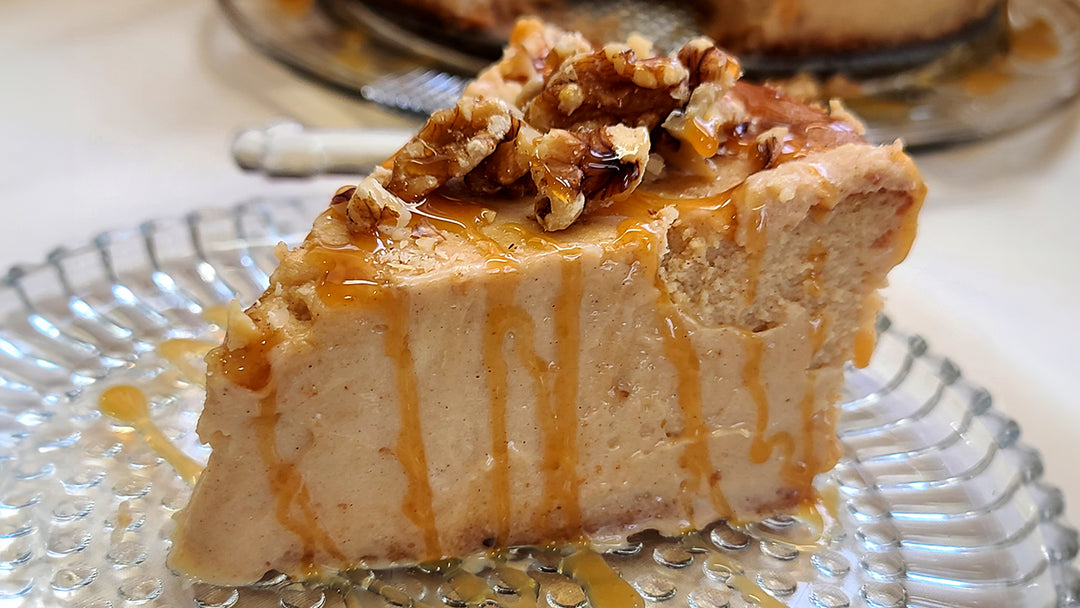 Maple Walnurt Cheesecake is plated with a drizzle of thickened maple syrup.