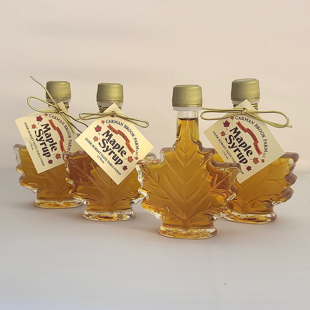 Small maple leaf bottles filled with dark robust taste maple syrup.