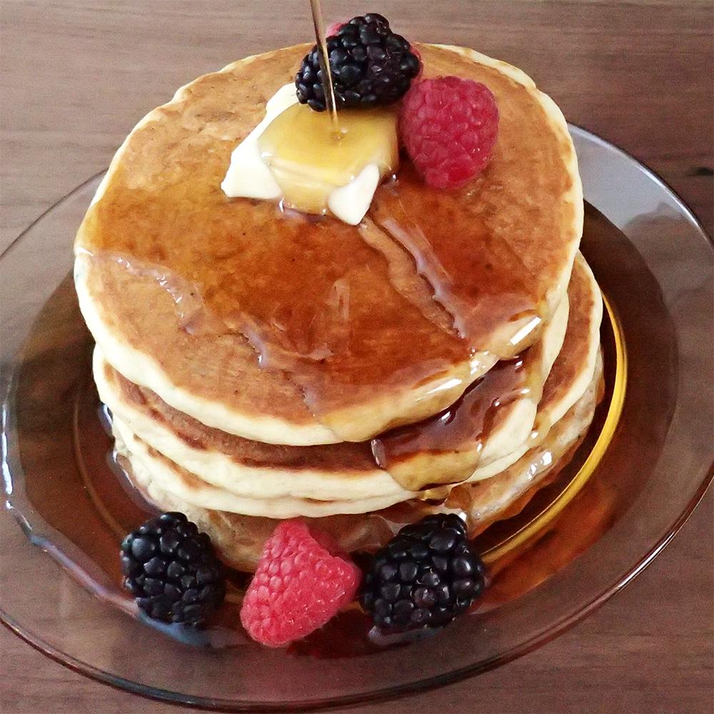 Pancakes, syrup, butter and fruit.